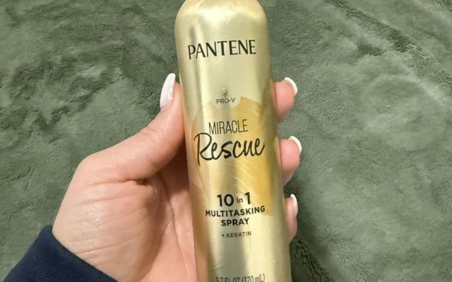 Hand holding Pantene miracle spray