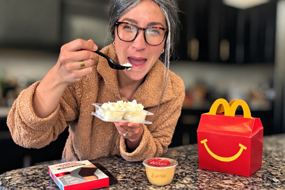 old woman eating mashed potatoes next to happy meal