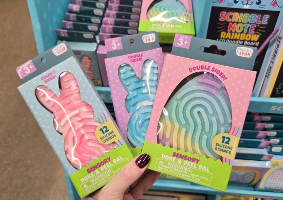 hand holding 3 sensory boards in easter shapes