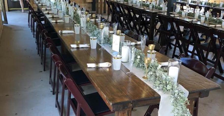 long table with candle vases and greenery