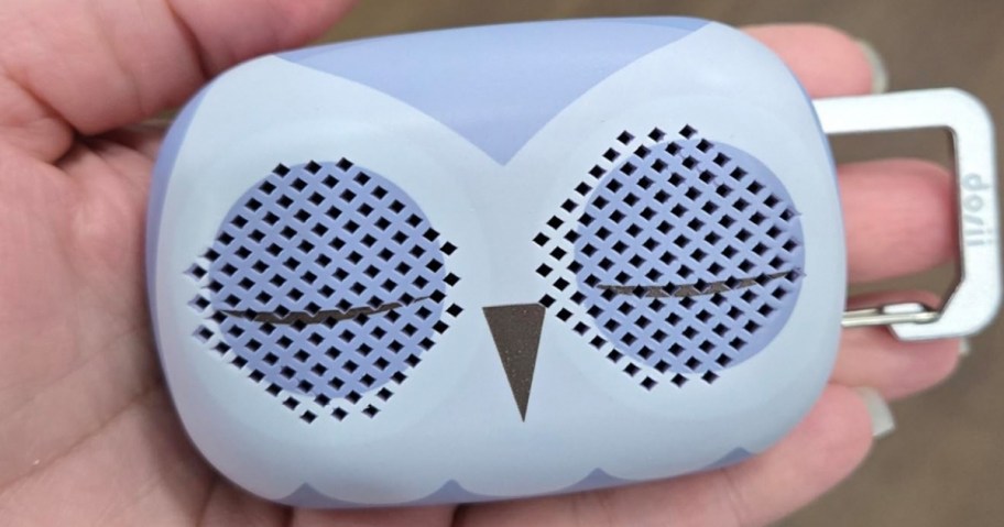 a womans hand holding a purple owl themed white noise machine