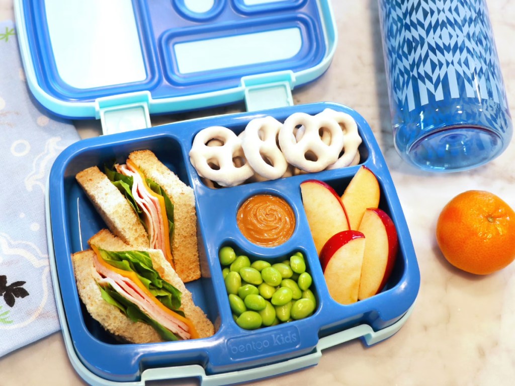 Blue bentgo, kids lunchbox filled with snacks and a sandwi