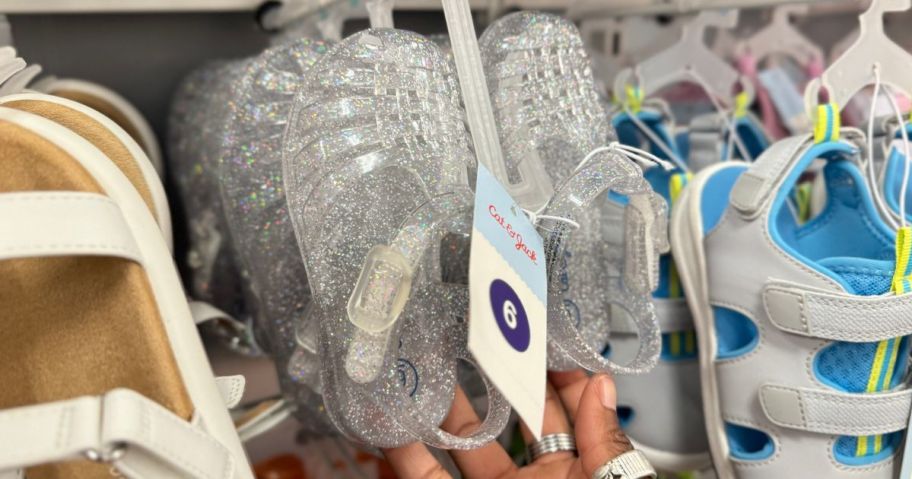 Hand touching a brand new pair of Cat & Jack Jelly Sandals at Target
