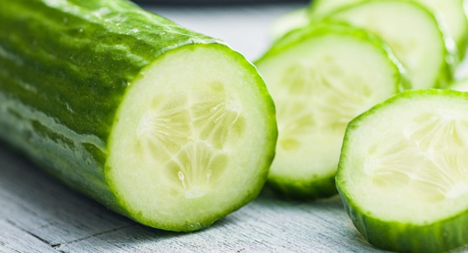 Cucumbers chopped up on a board in different size slices