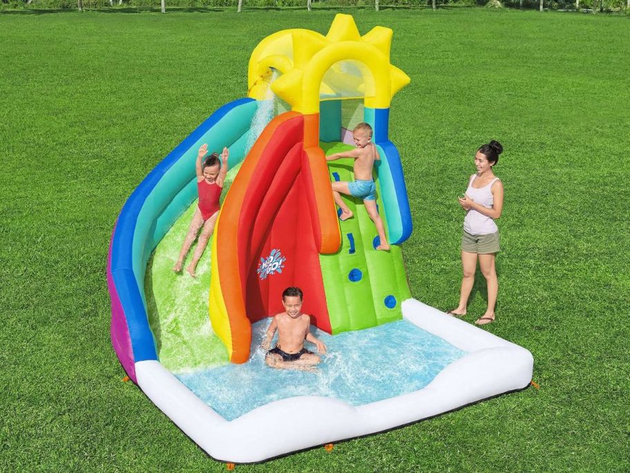 Kids playing on a large inflatable water park 