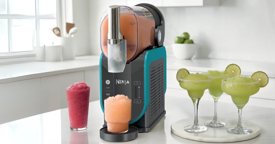 a Ninja SLUSHI drink maker machine with frozen drinks around it on a kitchen counter