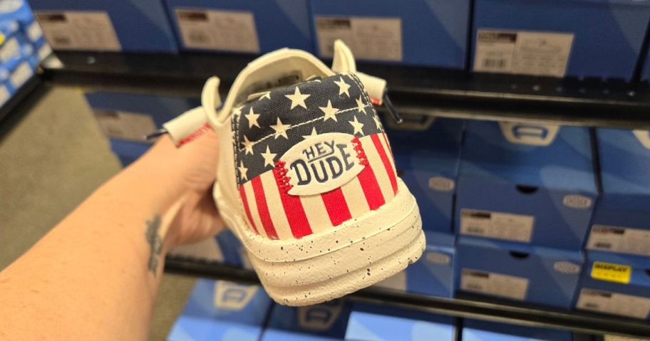 Hand Holding a pair of Patriotic Hey Dude Shoes