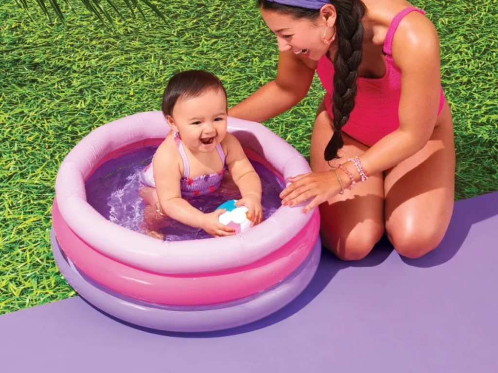 Mini pink and purple baby pool outside with mom and baby