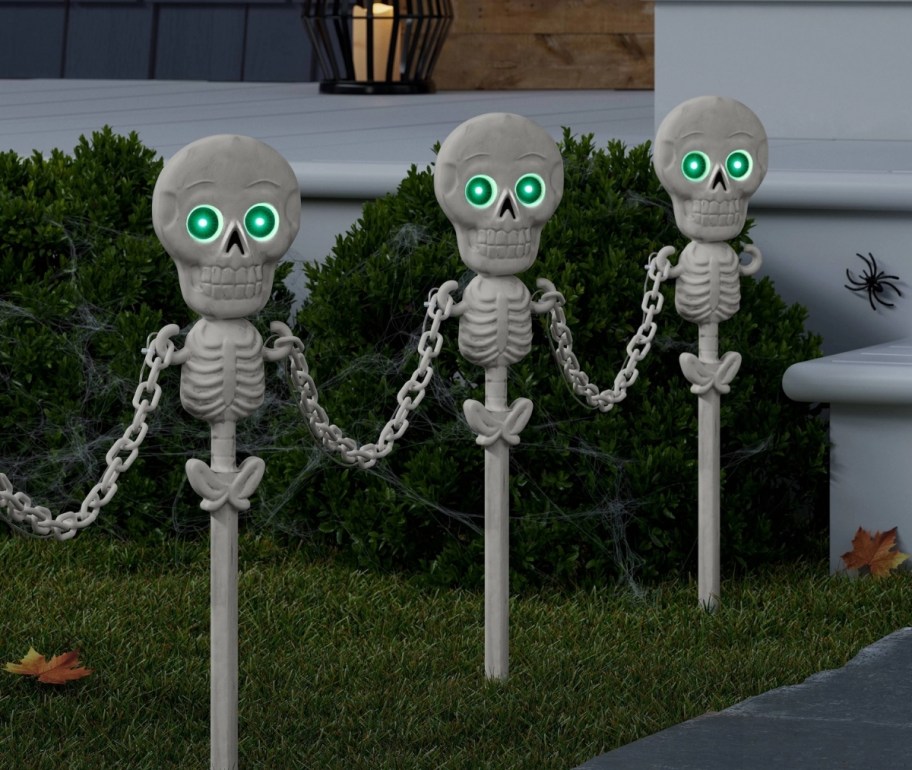 3 skeleton fence stakes with green glowing eyes