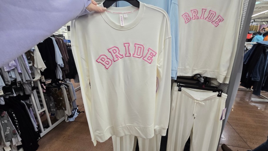 hand holding bride sweatshirt in store