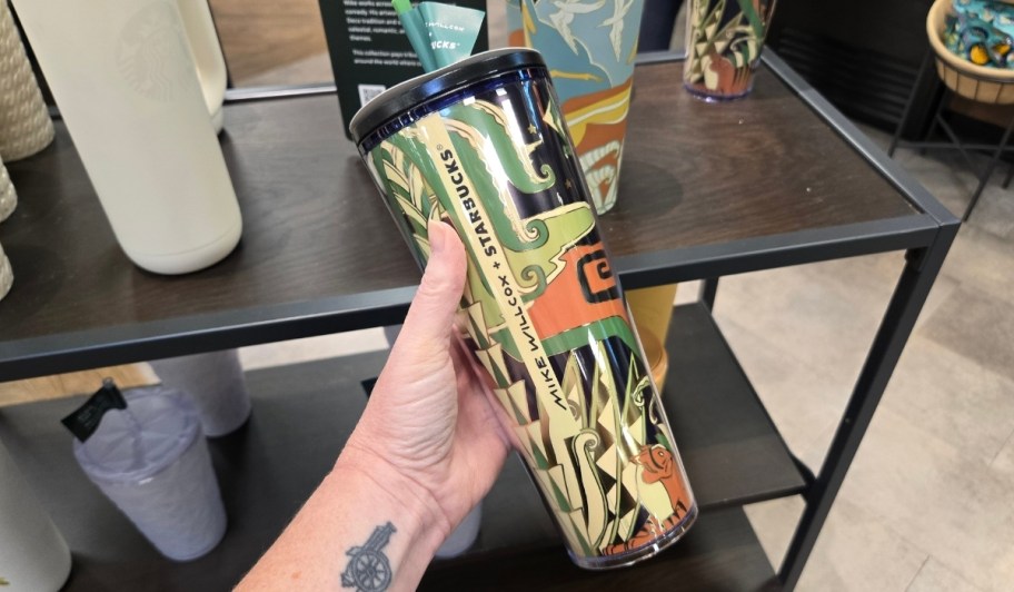 womans hand holding a deco inspired mike wilcox collab tumbler