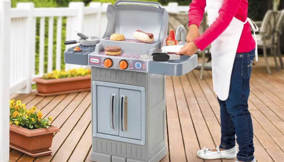kid playing with gray little tikes grill 