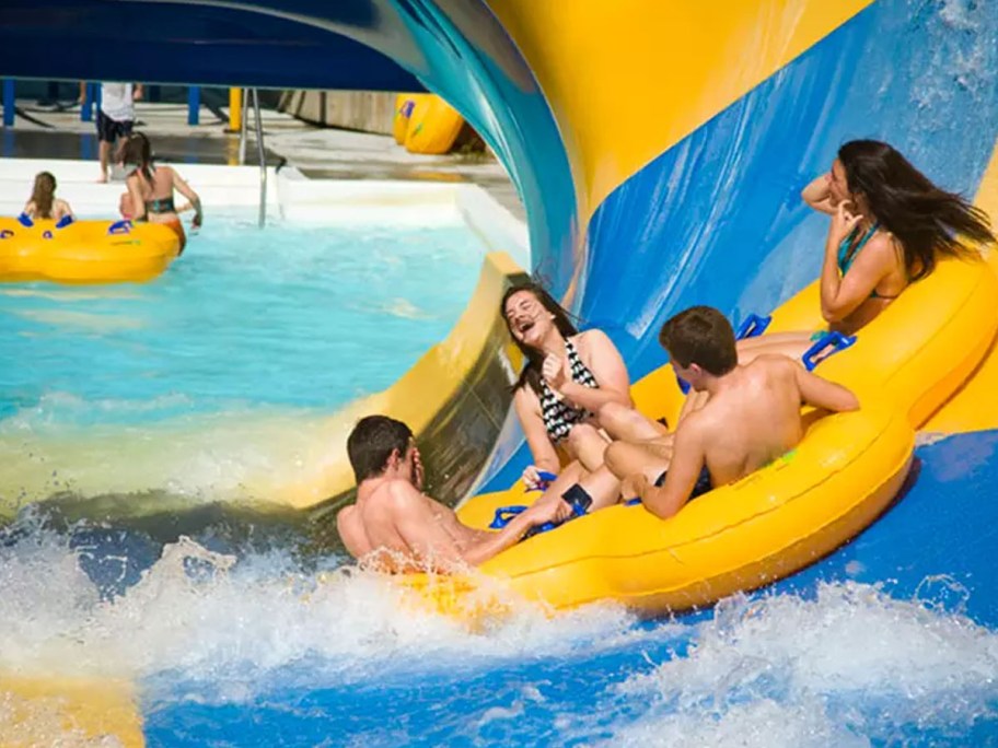 family in circle water raft ride on slide