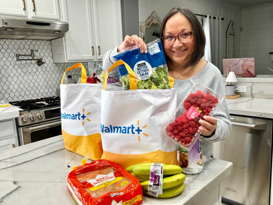 woman with bags of Walmart groceries standing at a kitchen counter