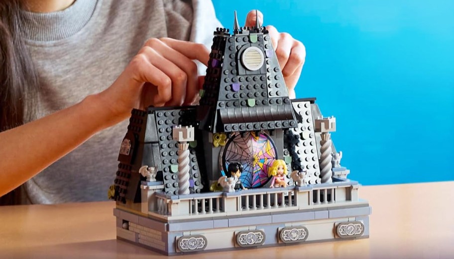 girl putting together LEGO Wednesday & Enid's Dorm Room Playset
