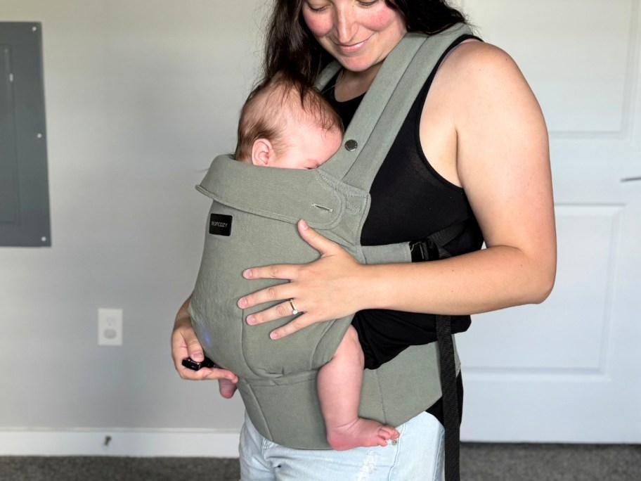 woman with a baby in a green baby carrier