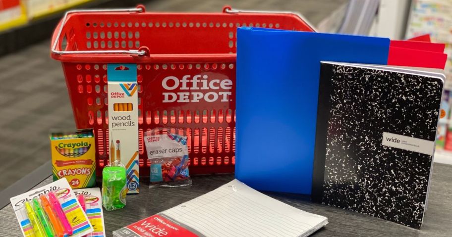 An office depot shopping basket surrounded by various school supplies like folders, composition books, filler paper, erasers, and pencils