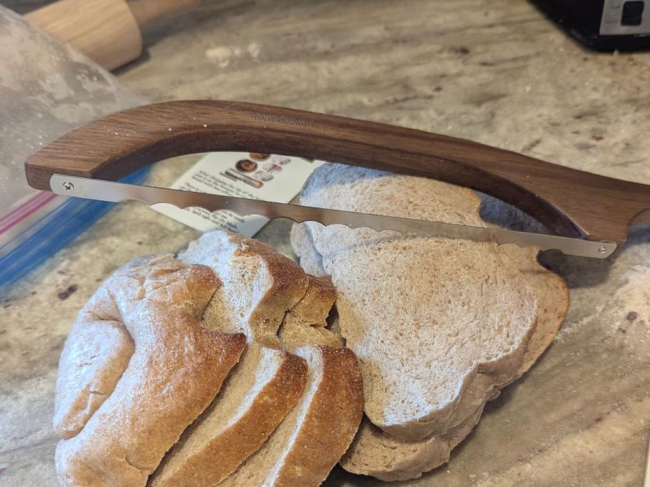 A bread knife on a cutting board with bread