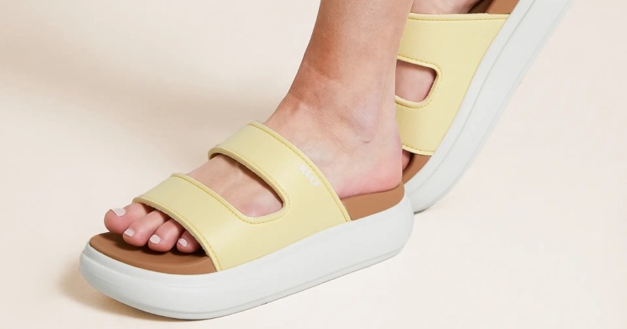 woman wearing Reef Women's Cushion Bondi Bar 2 Sandals in pale banana color