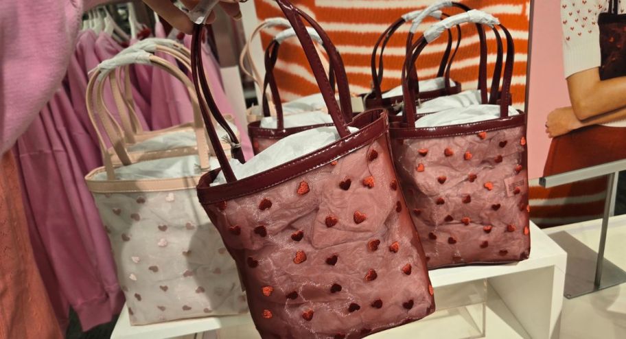 hand holding Valentine's day tote bag thats at the store 