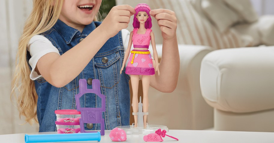 kid playing with pink playdoh barbie doll 