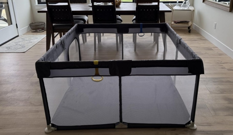 a small gray playpen assembled in a dining room