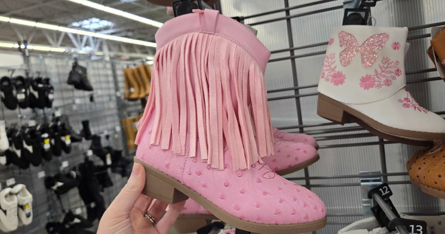 hand holding pink boots 