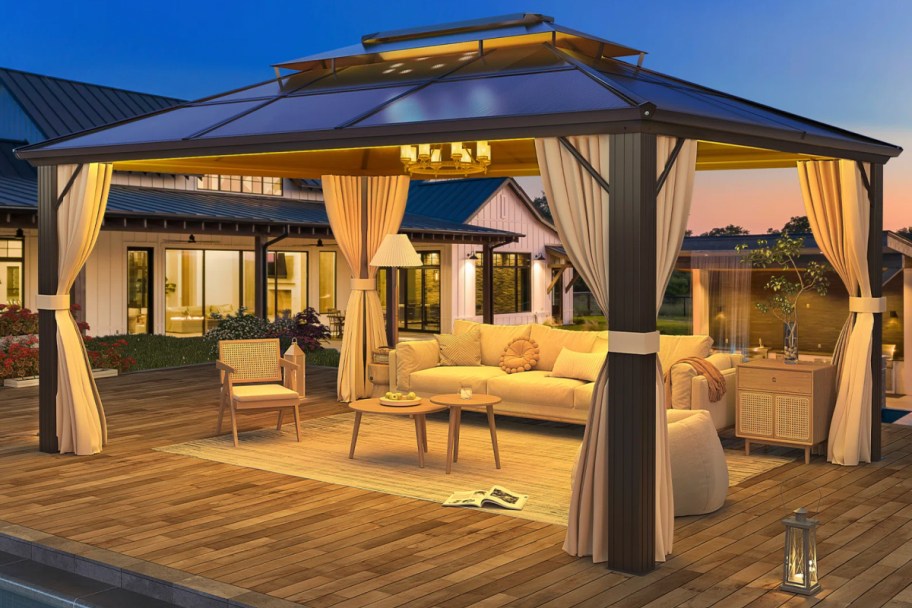 square gazebo over patio furniture at night