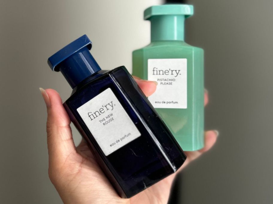 Hand holding two Fine'ry perfumes