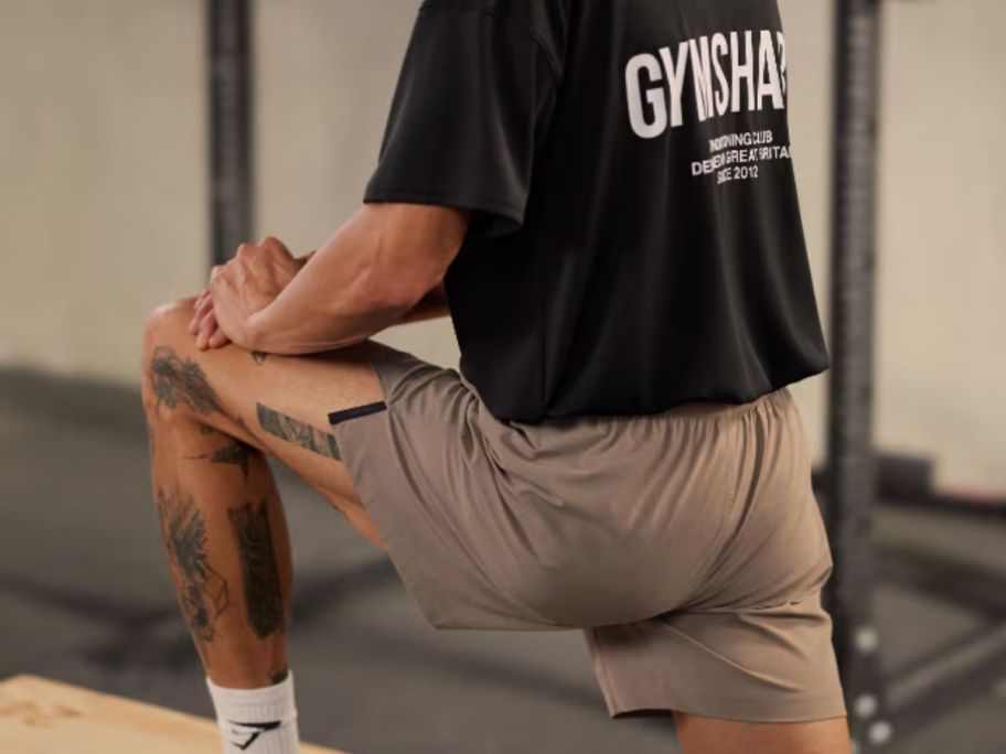 A man in a gym wearing tan shorts