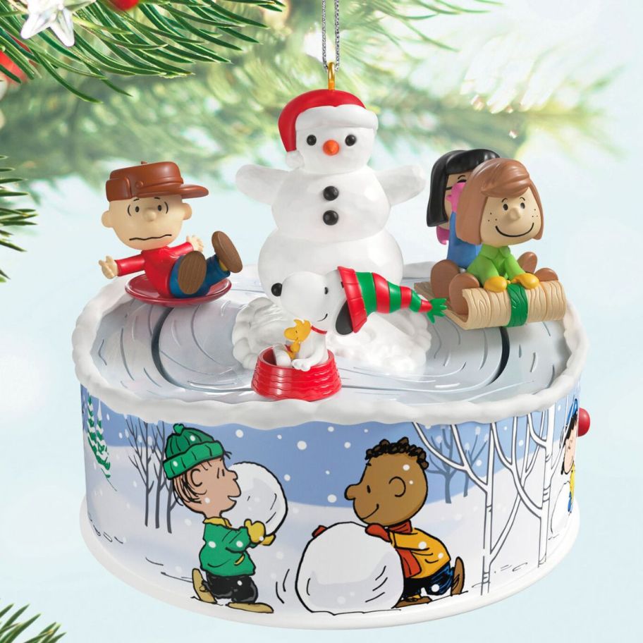 stock image of Hallmark The Peanuts Gang Let's Go Sledding! Musical Ornament w/ Light & Motion dangling froma. christmas tree