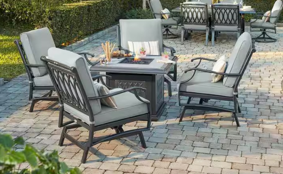 5 patio chairs with blue cushions around a fire pit