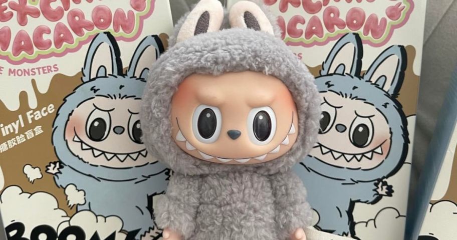 A labubu Macaron Series Plush Monster in front of labubu Mystery Boxes