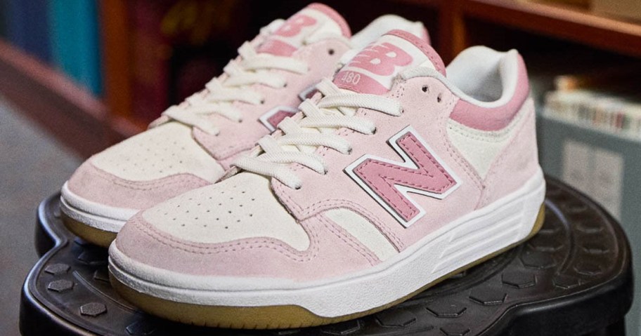 pair of pink new balance sneakers on a black stool