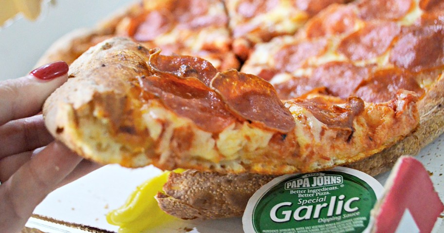 hand grabbing a slice of pepperoni pizza