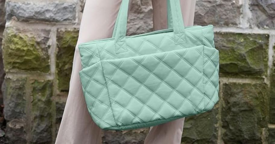 A woman carrying a teal quilted bag