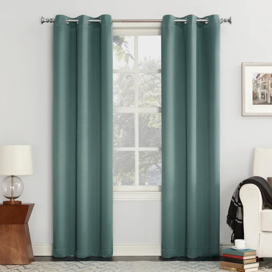 To teal colored curtain panels hanging on window 