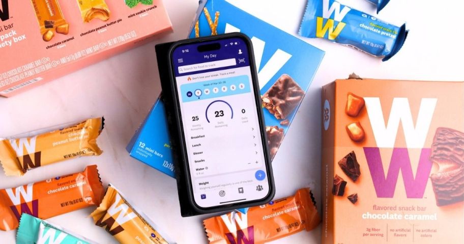 Weight Watchers App on a phone with prepackaged ww treats around it