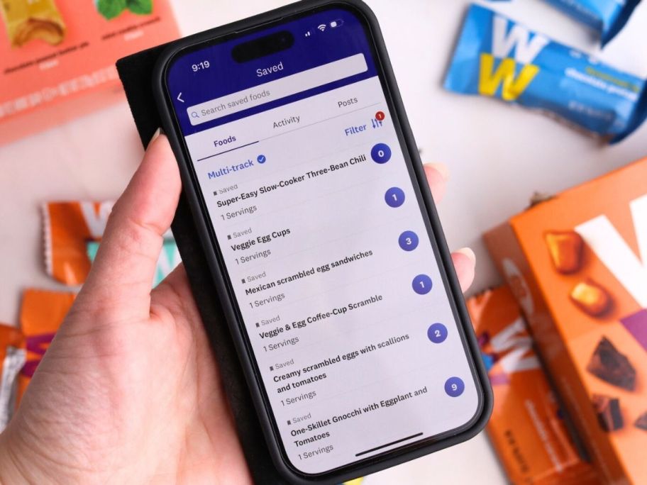 Hand holding a phone with the Weight Watchers App on it