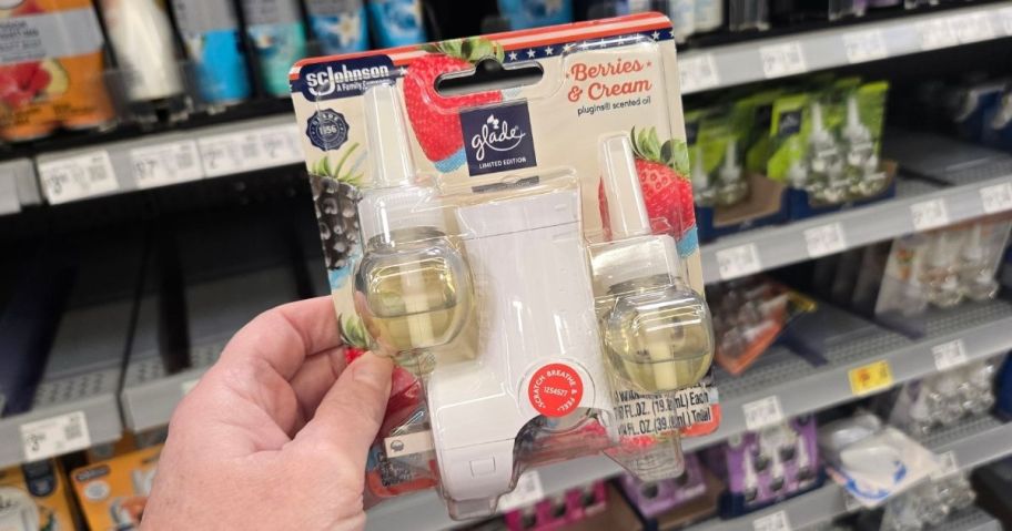 a womans hand holding a scent plugin starter kit