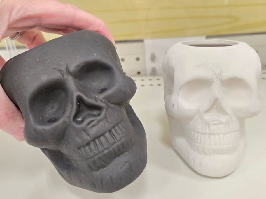 grey and white Terracotta Skull Vessels on shelf in store