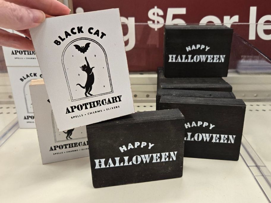 black and white Halloween Decor Signs on shelf in store