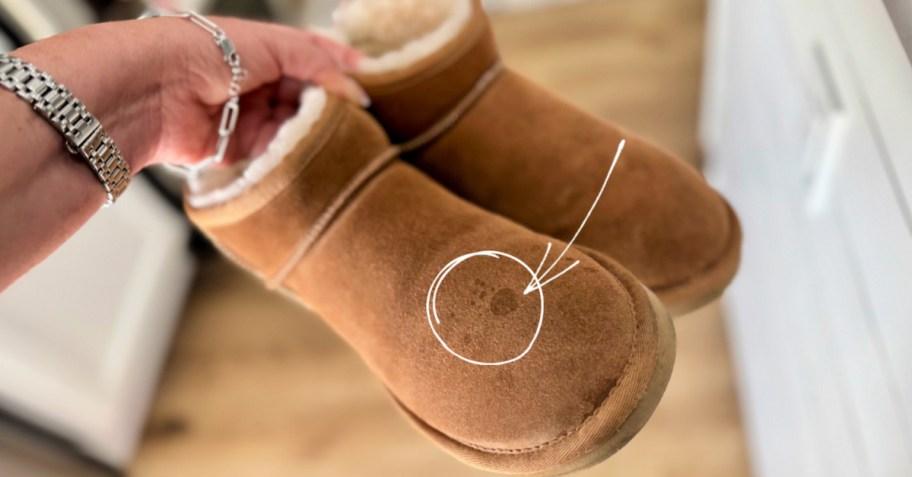 hand holding a pair of stained ugg boots