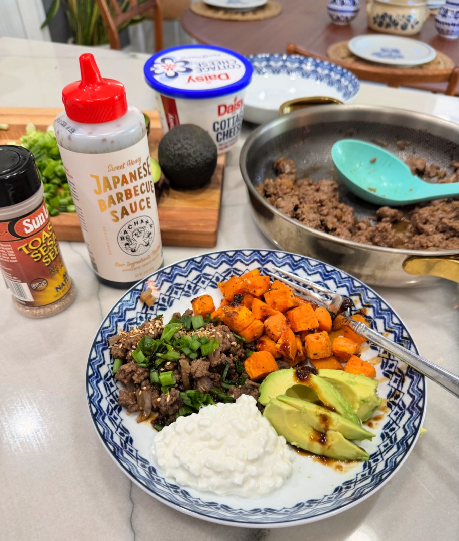 dishing up a korean beef bowl with cottage cheese and sliced avocado 