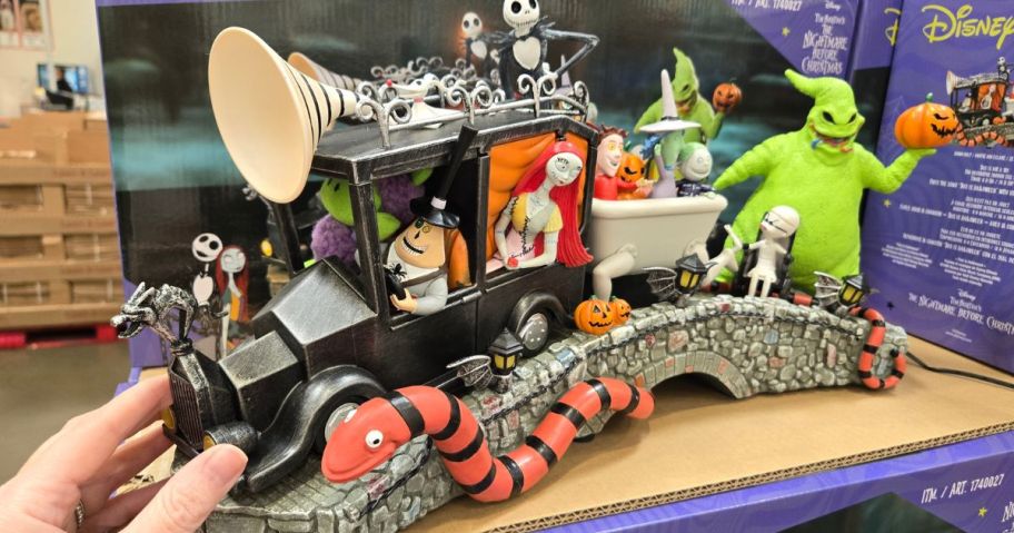 hand touching Disney Nightmare Before Christmas Mayor's Car Scene on shelf in store