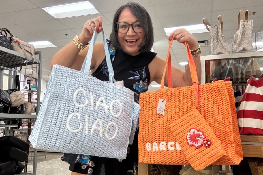 woman holding grey and orange straw tote bags