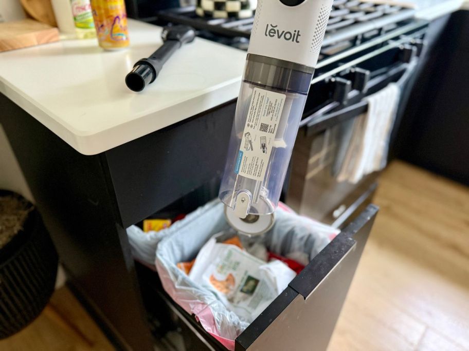 person emptying Levoit Cordless Vacuum Cleaner into garbage can