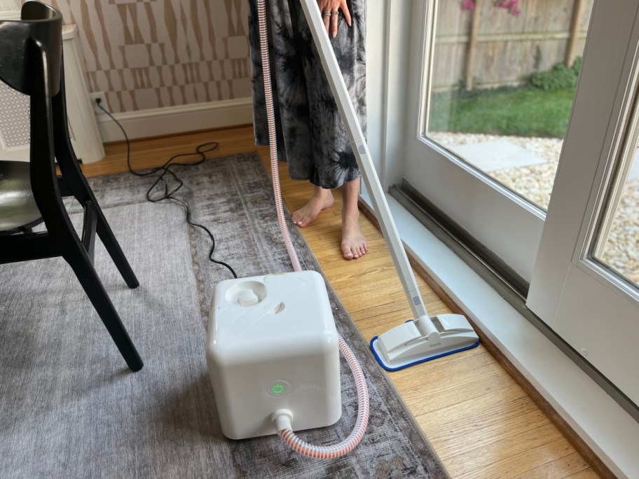 woman using white cube steamer on floors