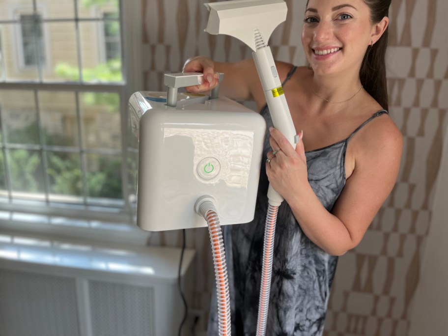 woman holding white cube steam cleaner