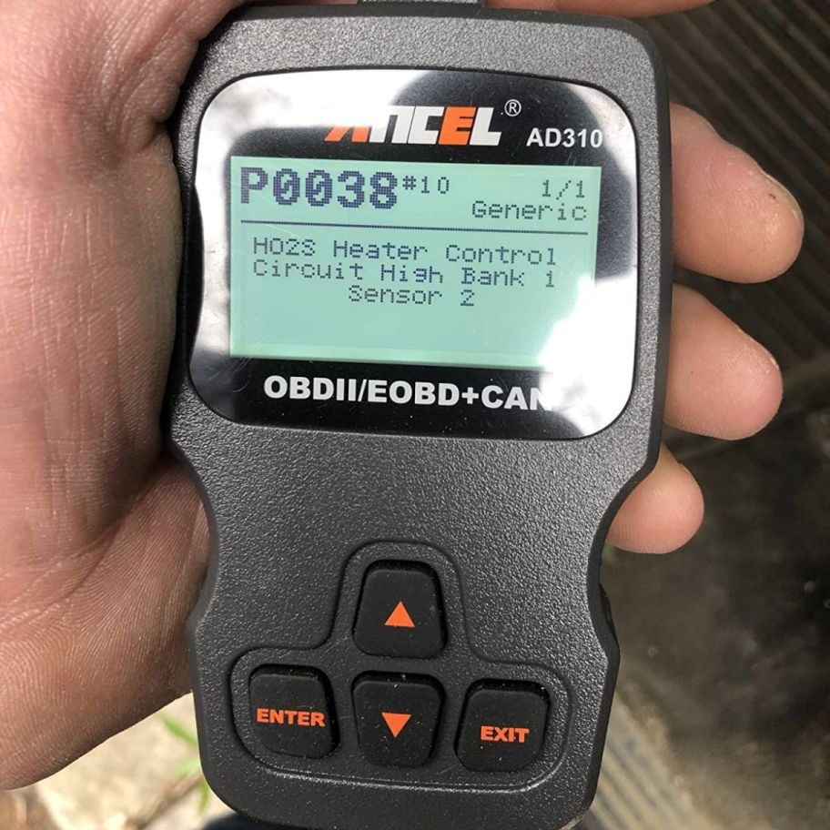 a mans hand holding an obd code reader